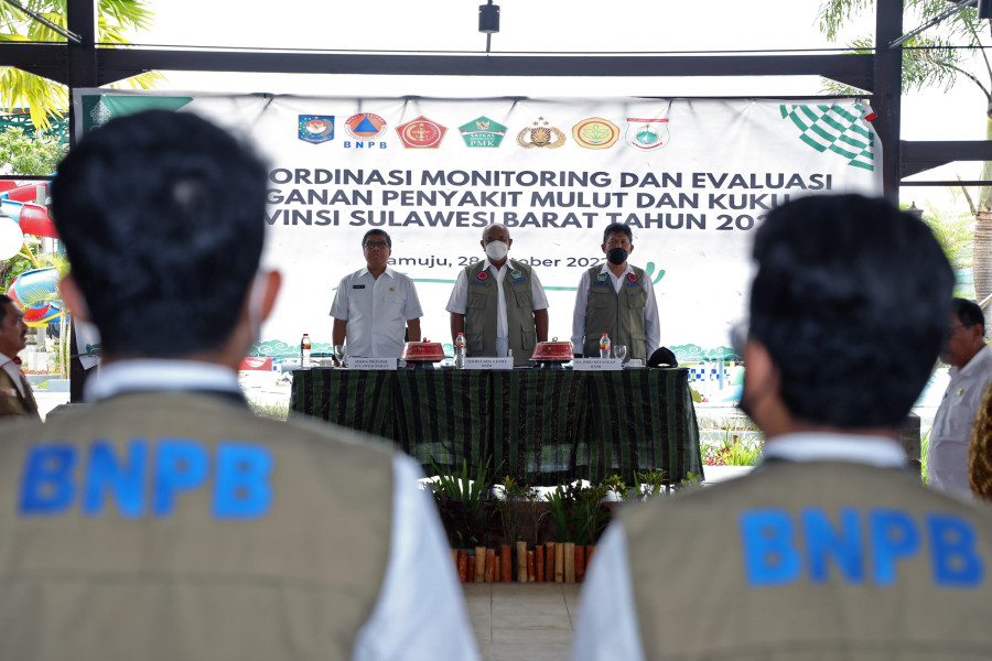 Sekretaris Utama BNPB Lilik Kurniawan (tengah depan) bersama Sekretaris Daerah Provinsi Sulawesi Barat Muhammad Idris (kiri depan) dan Kepala Biro Keuangan BNPB Tavip Joko (kanan depan) saat menyanyikan lagu Indonesia Raya sebelum memulai Rapat Koordinasi Monitoring dan Evaluasi Penanganan Penyakit Mulut dan Kuku di Provinsi Sulawesi Barat, Jumat (28/10).