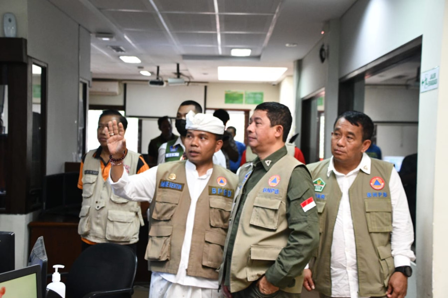 Kepala Pelaksana BPBD Provinsi Bali I Made Rentin (kiri) memberikan penjelasan terkait aktivitas monitoring prakiraan cuaca wilayah Provinsi Bali kepada Kepala BNPB Letjen TNI Suharyanto (tengah) dan Deputi Bidang Penanganan Darurat BNPB Mayjen TNI Fajar Setyawan di Kantor BPBD Provinsi Bali, Denpasar, Minggu (13/11).