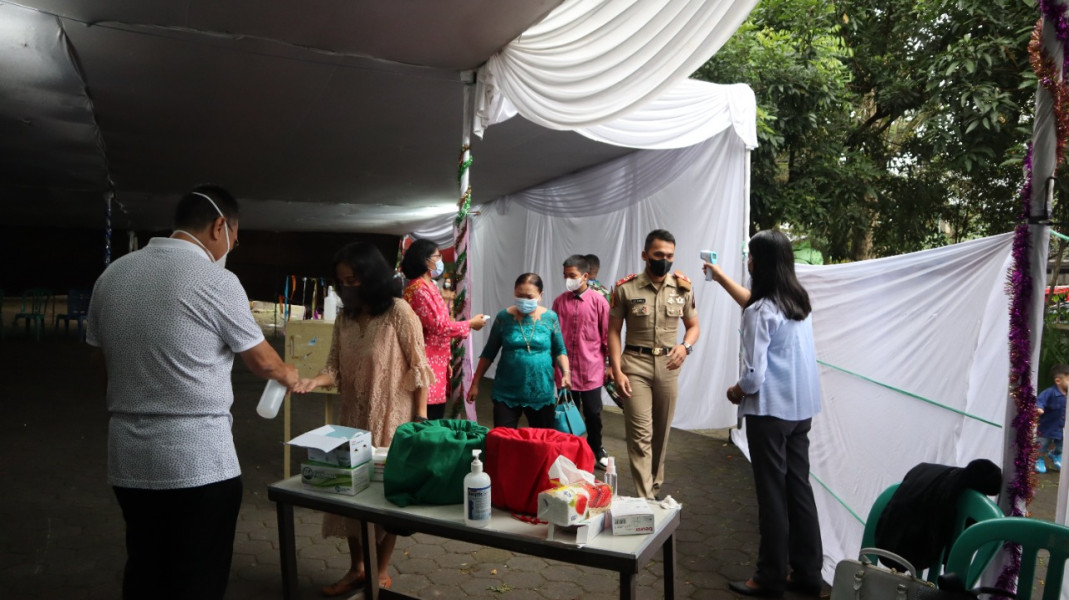 Panitia melakukan screening awal kepada jemaat yang hendak mengikuti perayaan natal di Gereja Santo Petrus, Cianjur, Jawa Barat, Minggu (25/12).