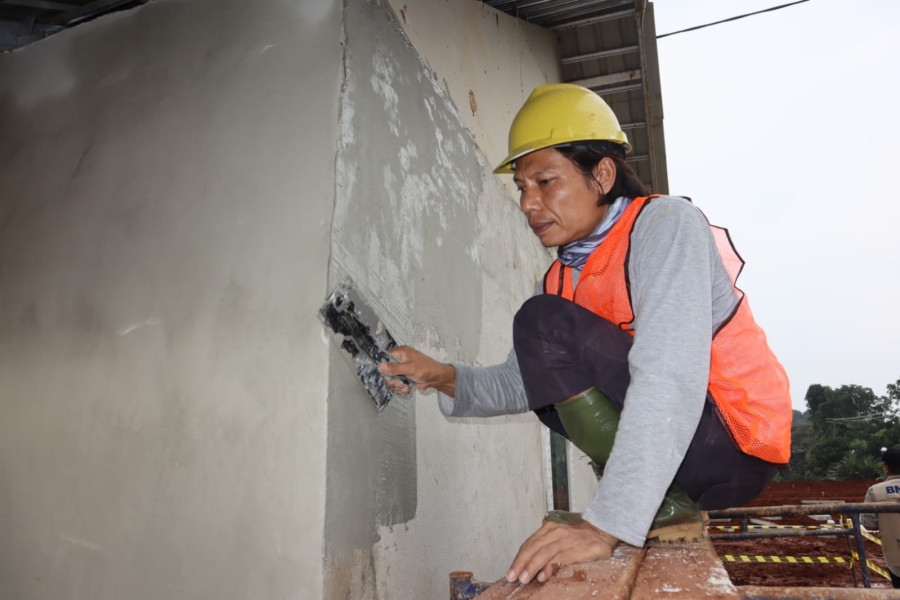 Sejumlah pekerja bangunan sedang mengerjakan rumah tahan gempa RISHA, yang disediakan bagi warga terdampak gempa di Desa Sirnagalih, Kec. Cilaku, Kec. Cugenang, Kab. Cianjur, Jawa Barat, Senin (5/12).