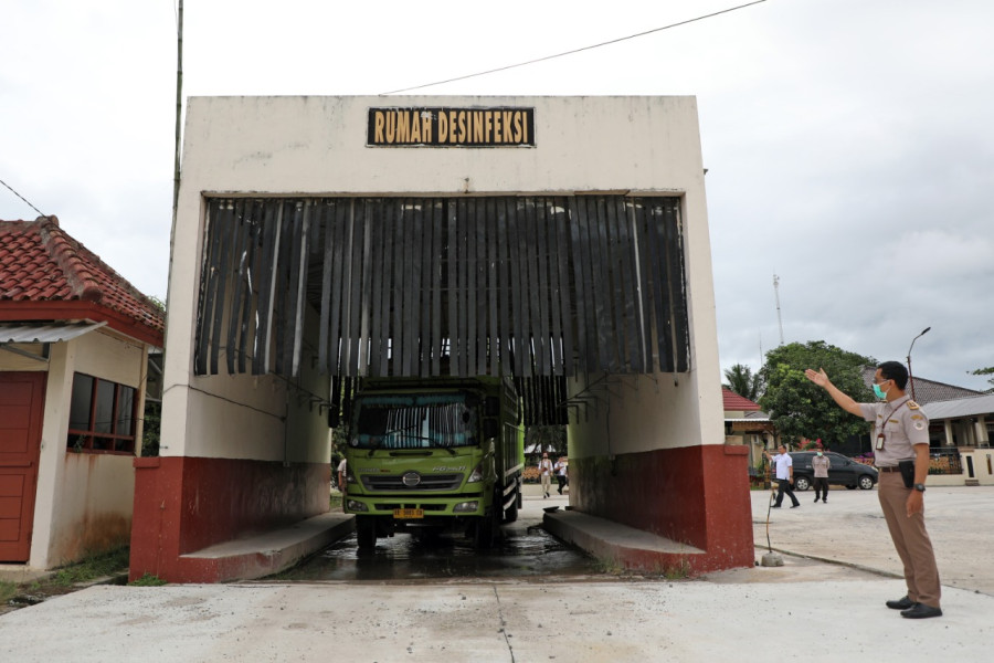 Petugas Balai Karantina Pertanian Kelas I Wilker Bakauheni memandu proses disinfeksi biosecurity kendaraan dan hewan ternak sebelum melanjutkan perjalanan sampai ke tujuan untuk mencegah terjadinya penularan penyakit PMK.