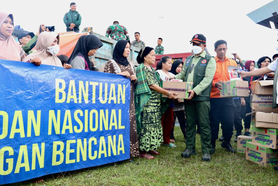 Kepala BNPB Letjen TNI Suharyanto (rompi hijau) menyerahkan bantuan kepada warga pengungsian di Stadion Manakarra, Mamuju, Sulawesi Barat, Kamis (9/6).