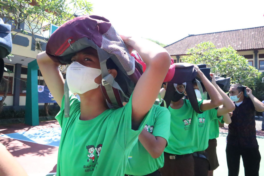 Para siswa mengikuti simulasi evakuasi mandiri gempabumi dan tsunami di SMPN 3 Kuta Selatan, Kecamatan Kuta Selatan, Kabupaten Badung, Provinsi Bali, Jumat (22/4).