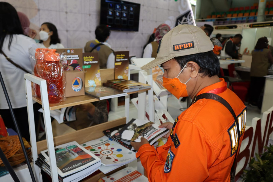 Salah satu peserta sedang membaca produk literasi kebencanaan di _Booth_ BNPB pada pameran kebencanaan Bulan Pengurangan Risiko Bencana di Balikpapan, Kalimantan Timur, Rabu (12/10).