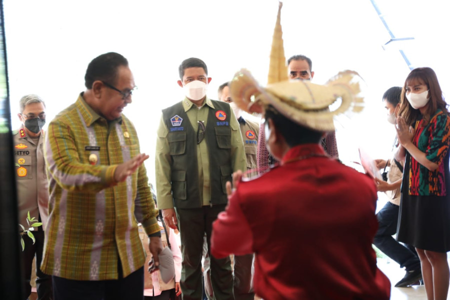 Kepala BNPB Letjen TNI Suharyanto (baju hijau rompi) disambut tarian selamat datang dalam agenda Rapat Koordinasi percepatan pelaksanaan bantuan stimulan rumah pascabencana Siklon Tropis Seroja di Aula Kantor Gubernur, Kupang, NTT, Kamis (12/5).